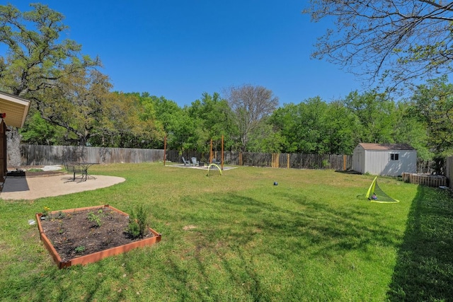 view of yard with a fenced backyard, an outdoor structure, a vegetable garden, and a shed