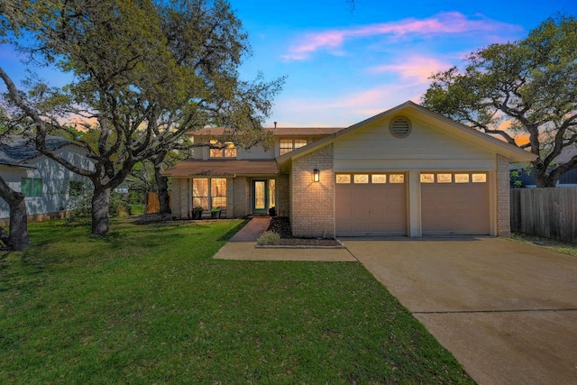 view of front of house with concrete driveway, fence, an attached garage, a front yard, and brick siding