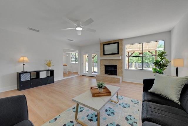 living room with baseboards, visible vents, ceiling fan, and wood finished floors