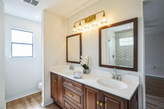 full bathroom with wood finished floors, a sink, plenty of natural light, and visible vents