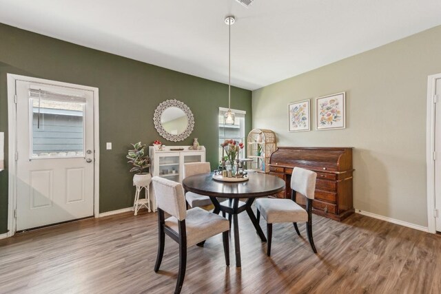14128 Sandrock Bnd, Pflugerville, TX 78660 - dining space featuring wood finished floors, plenty of natural light, and baseboards