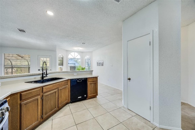 kitchen featuring light countertops, visible vents, black dishwasher, a sink, and brown cabinetry