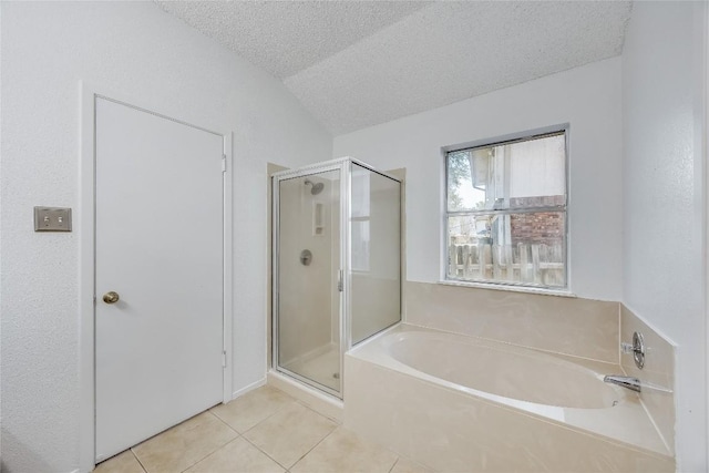 bathroom with a stall shower, a garden tub, tile patterned flooring, and a textured ceiling