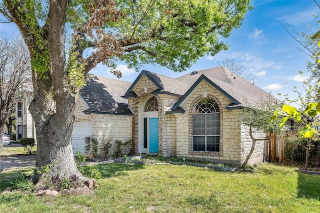 french country home with stone siding, a garage, roof with shingles, and a front yard