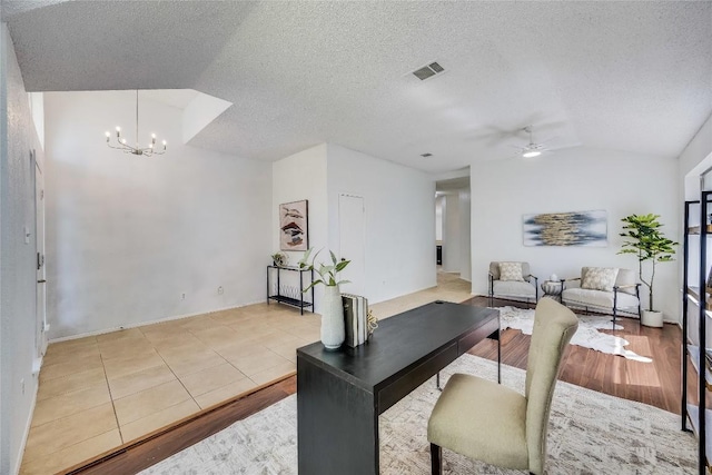 tiled office featuring a textured ceiling, ceiling fan with notable chandelier, vaulted ceiling, and visible vents