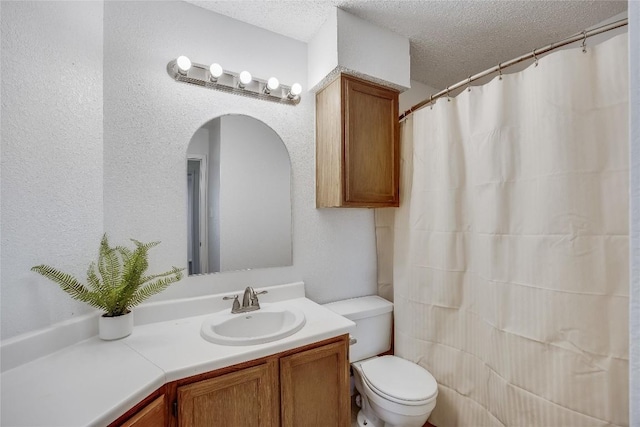 full bathroom with toilet, vanity, and a textured ceiling