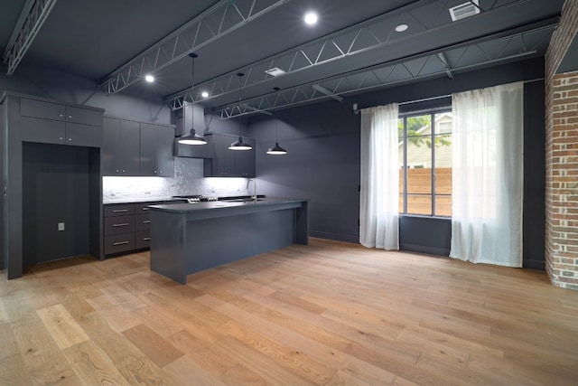 933 E 52nd St, Austin, TX 78751 - kitchen featuring decorative backsplash, light wood-type flooring, a sink, and dark countertops