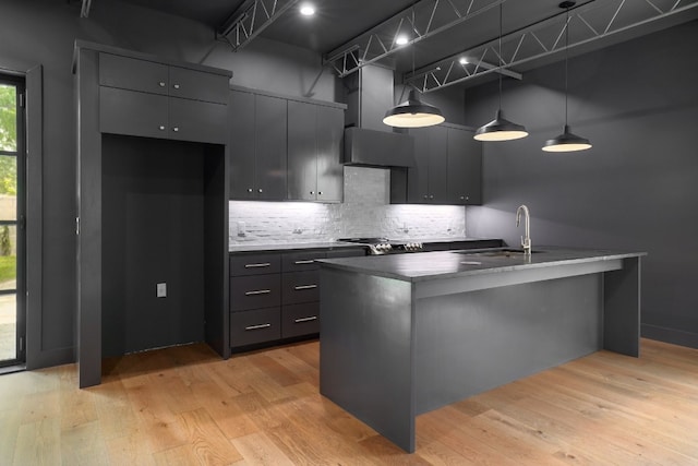 933 E 52nd St, Austin, TX 78751 - kitchen with a sink, wall chimney range hood, backsplash, and light wood-type flooring