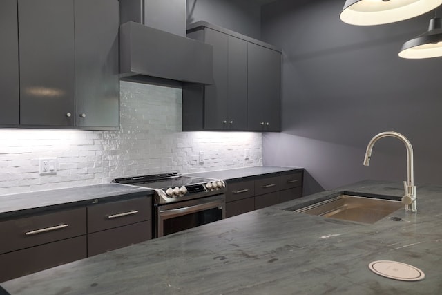 933 E 52nd St, Austin, TX 78751 - kitchen with stainless steel range with electric stovetop, a sink, decorative backsplash, wall chimney range hood, and dark stone counters