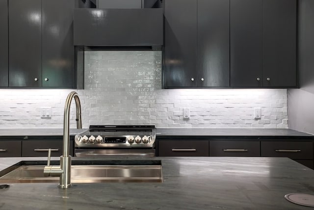 933 E 52nd St, Austin, TX 78751 - kitchen featuring electric stove, backsplash, and dark cabinets