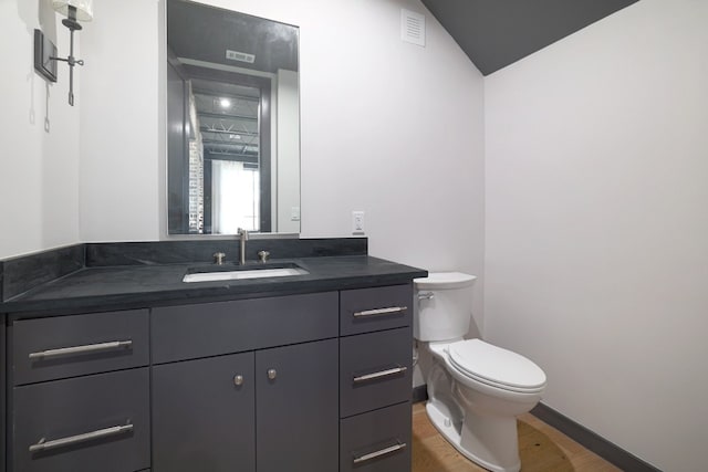 933 E 52nd St, Austin, TX 78751 - half bathroom with toilet, vanity, wood finished floors, and baseboards