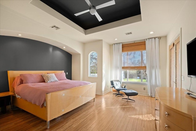 11801 Astoria Dr, Bee Cave, TX 78738 - bedroom featuring a raised ceiling, light wood-style flooring, recessed lighting, baseboards, and a ceiling fan