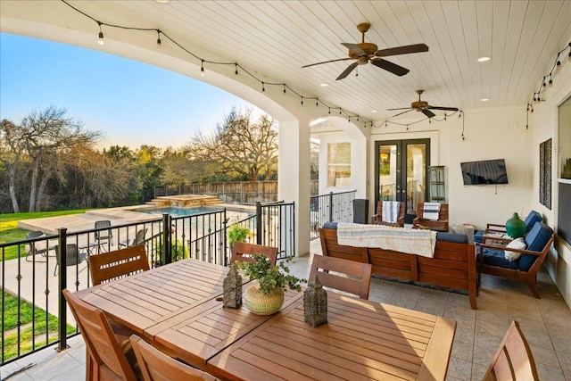 balcony with an in ground hot tub, outdoor lounge area, outdoor dining space, and french doors