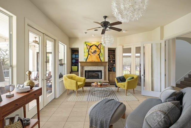 11801 Astoria Dr, Bee Cave, TX 78738 - living area with light tile patterned floors, french doors, ceiling fan, a glass covered fireplace, and arched walkways