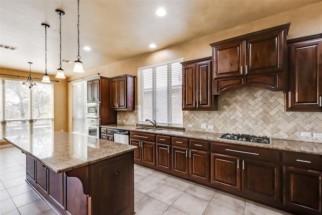 3519 Alexandrite Way, Round Rock, TX 78681 - kitchen featuring stainless steel appliances, backsplash, light tile patterned floors, a kitchen island, and light stone counters