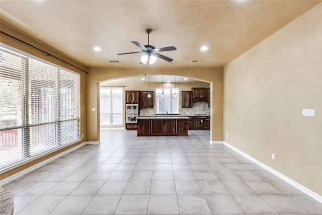 3519 Alexandrite Way, Round Rock, TX 78681 - unfurnished living room featuring arched walkways, ceiling fan, recessed lighting, and light tile patterned flooring