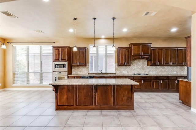 3519 Alexandrite Way, Round Rock, TX 78681 - kitchen featuring appliances with stainless steel finishes, a kitchen island, decorative backsplash, plenty of natural light, and recessed lighting
