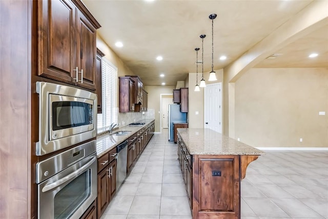 3519 Alexandrite Way, Round Rock, TX 78681 - kitchen with stainless steel appliances, a kitchen island, light stone countertops, hanging light fixtures, and recessed lighting