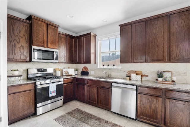 366 Eagle Brook Ln, Buda, TX 78610 - kitchen featuring stainless steel appliances, light tile patterned flooring, light stone countertops, backsplash, and recessed lighting