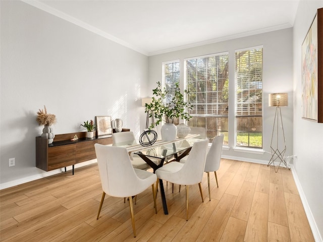 dining area with crown molding, baseboards, and light wood-type flooring