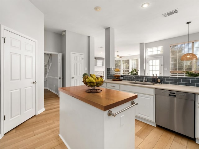 11009 Savannah Ct, Austin, TX 78739 - kitchen featuring stainless steel dishwasher, wood counters, white cabinets, tasteful backsplash, and light wood-type flooring