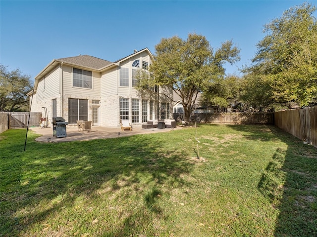 rear view of house featuring a fenced backyard, an outdoor living space, a patio area, and a lawn