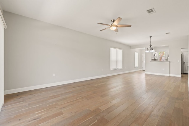 210 Crockett Loop, Georgetown, TX 78633 - unfurnished living room featuring ceiling fan, light wood finished floors, a chandelier, and baseboards