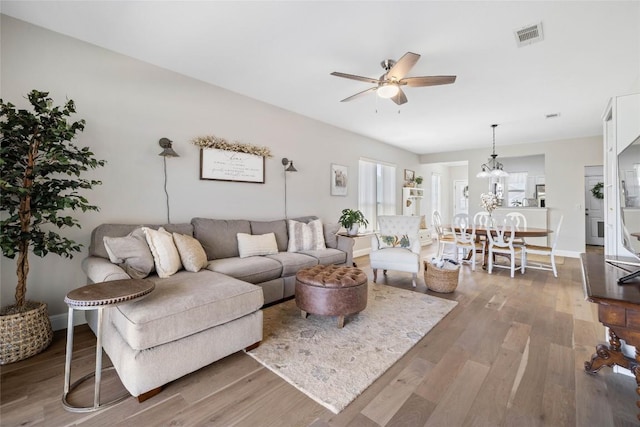 210 Crockett Loop, Georgetown, TX 78633 - living room featuring ceiling fan, plenty of natural light, wood finished floors, and a chandelier