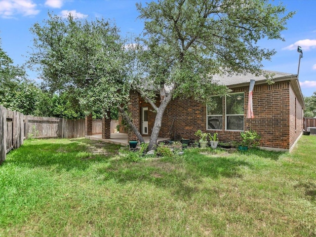 1501 Uhland Dr, Leander, TX 78641 - back of property with brick siding, a fenced backyard, and a patio