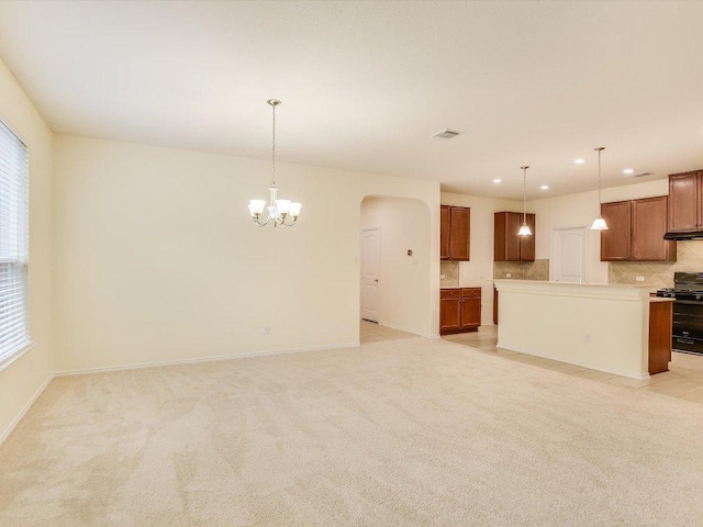 1501 Uhland Dr, Leander, TX 78641 - kitchen with gas stove, brown cabinetry, a chandelier, decorative backsplash, and arched walkways