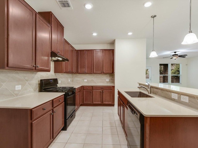 1501 Uhland Dr, Leander, TX 78641 - kitchen with black appliances, under cabinet range hood, pendant lighting, decorative backsplash, and light countertops