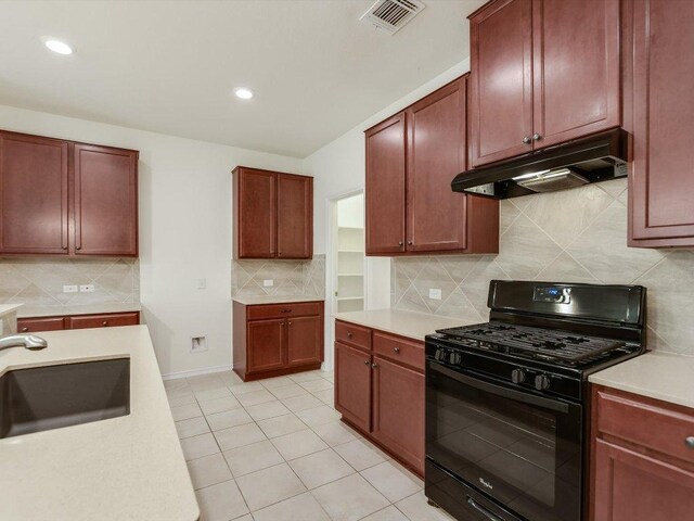 1501 Uhland Dr, Leander, TX 78641 - kitchen with black gas range, under cabinet range hood, light countertops, tasteful backsplash, and recessed lighting