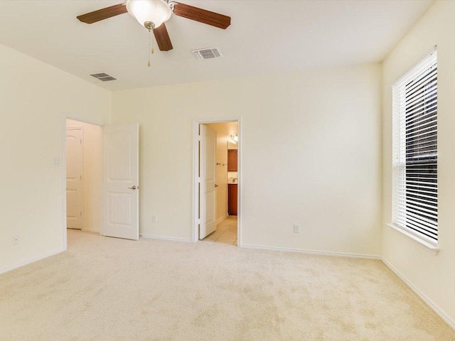 1501 Uhland Dr, Leander, TX 78641 - unfurnished bedroom featuring light carpet, ensuite bathroom, and ceiling fan