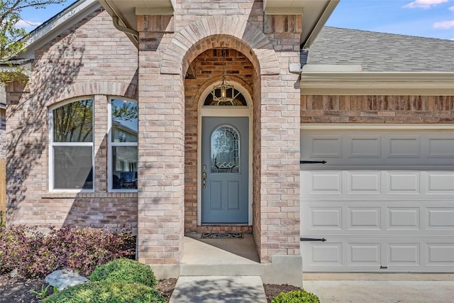 2974 Overland St, Round Rock, TX 78681 - doorway to property with roof with shingles, brick siding, and a garage
