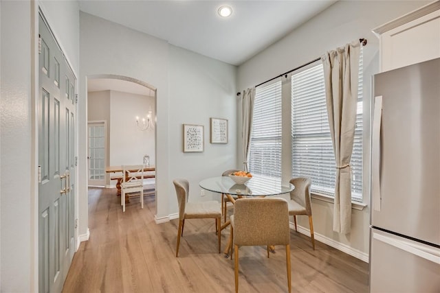 2974 Overland St, Round Rock, TX 78681 - dining room featuring light wood finished floors, arched walkways, a chandelier, and recessed lighting