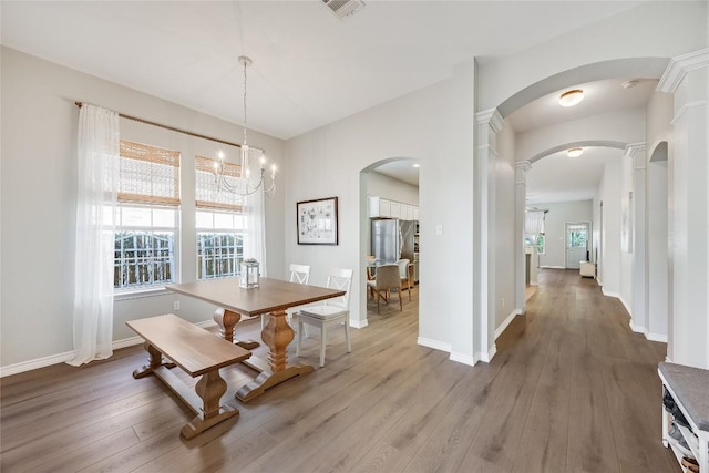 2974 Overland St, Round Rock, TX 78681 - dining area with a chandelier, wood finished floors, and arched walkways