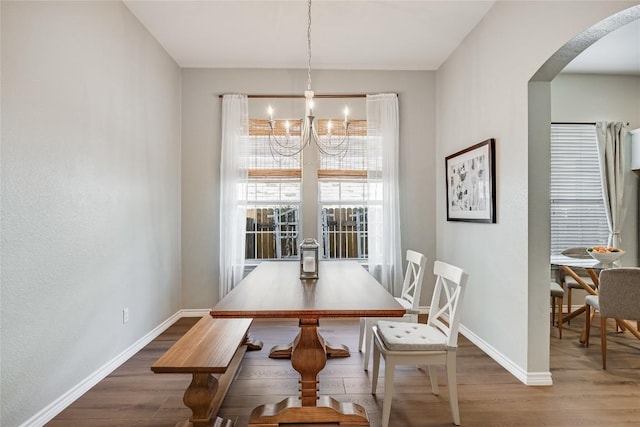 2974 Overland St, Round Rock, TX 78681 - dining area featuring arched walkways, a chandelier, and wood finished floors