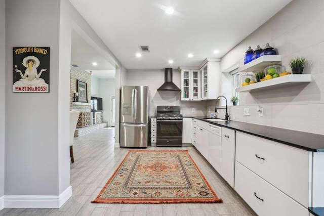 6608 Breezy Pass, Austin, TX 78749 - kitchen featuring stainless steel appliances, wall chimney range hood, dark countertops, light wood-style flooring, and white cabinets