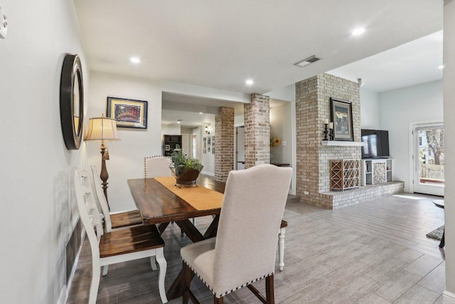 6608 Breezy Pass, Austin, TX 78749 - dining room with a brick fireplace, wood finished floors, and recessed lighting