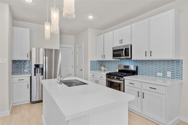 1512 Honaker Way, Leander, TX 78641 - kitchen with appliances with stainless steel finishes, a sink, backsplash, a kitchen island with sink, and light wood-style floors