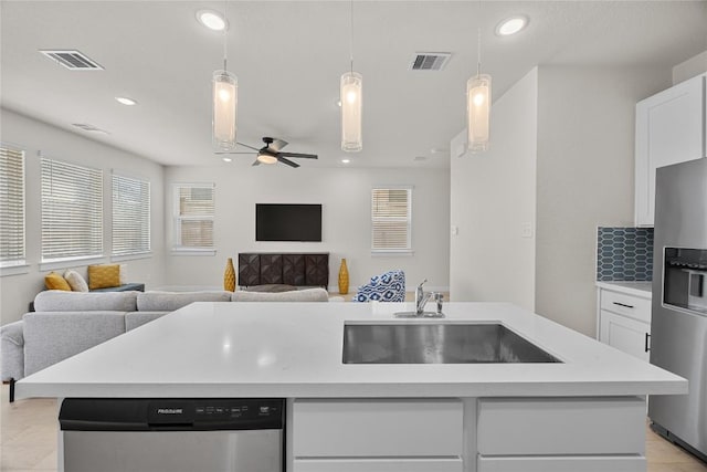 1512 Honaker Way, Leander, TX 78641 - kitchen with stainless steel appliances, open floor plan, a sink, light countertops, and ceiling fan