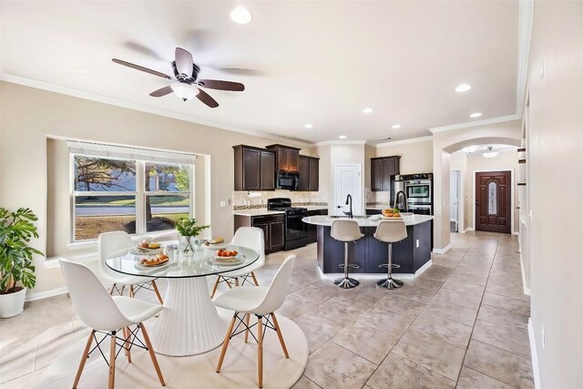 dining space with crown molding, baseboards, ceiling fan, recessed lighting, and arched walkways