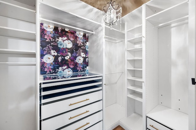 spacious closet with a chandelier