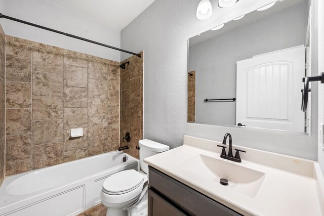 bathroom with a textured wall,  shower combination, toilet, and vanity