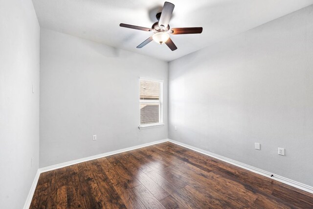 unfurnished room with dark wood-type flooring, ceiling fan, and baseboards