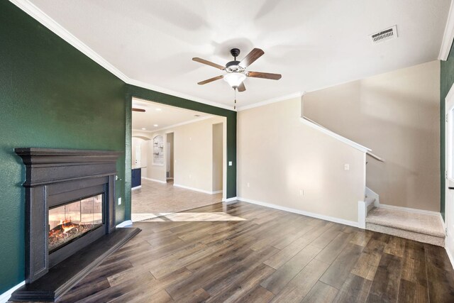 unfurnished living room with visible vents, ceiling fan, wood finished floors, stairway, and a multi sided fireplace