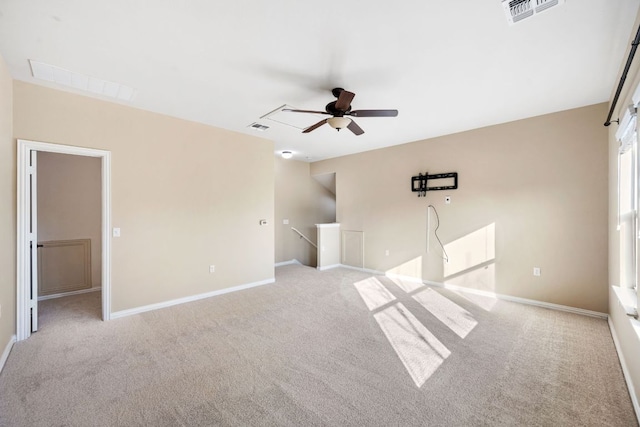 interior space featuring baseboards, visible vents, and light carpet