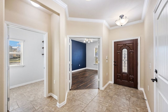 foyer entrance with baseboards and ornamental molding