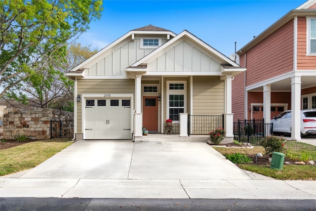 view of front of property featuring covered porch, concrete driveway, fence, board and batten siding, and a garage