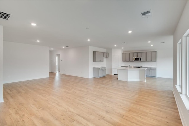 544 Tekoa Dr, Georgetown, TX 78628 - unfurnished living room featuring visible vents, recessed lighting, and light wood-type flooring